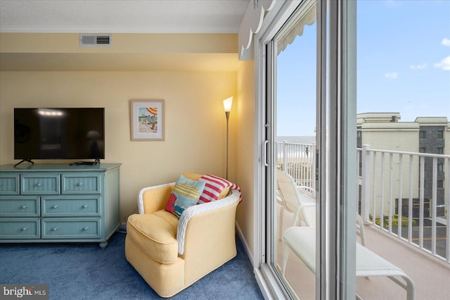 living area with carpet floors, a textured ceiling, and ornamental molding