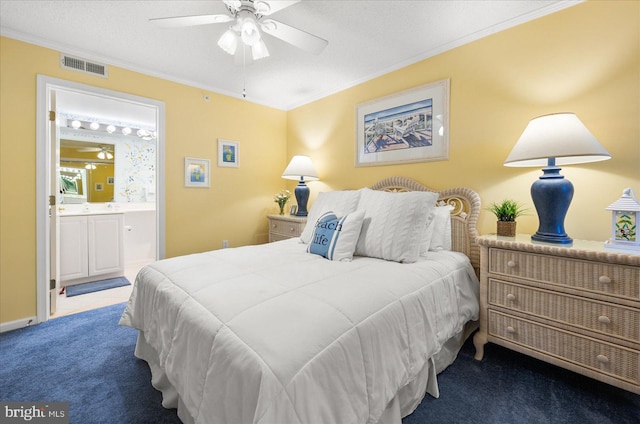 bedroom featuring ceiling fan, connected bathroom, dark colored carpet, and crown molding