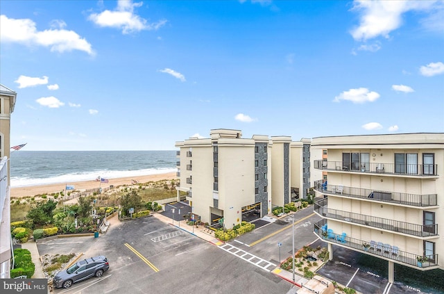 view of building exterior with a water view and a beach view