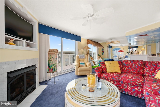 carpeted living room featuring ceiling fan, a fireplace, and a textured ceiling