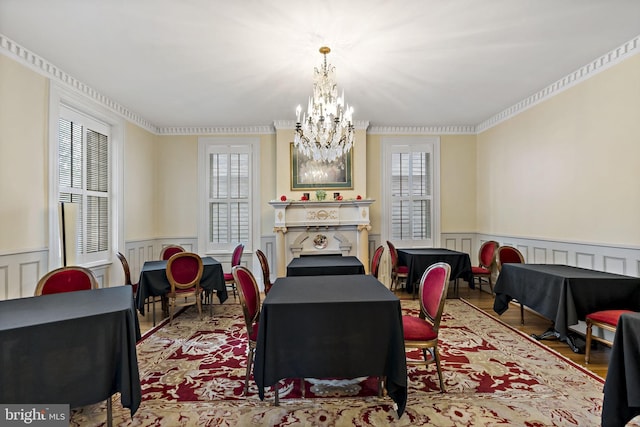 interior space featuring a notable chandelier, light wood-type flooring, crown molding, and a healthy amount of sunlight