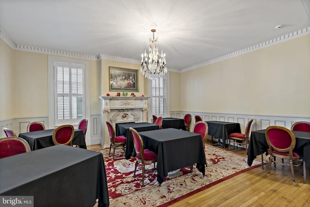 interior space featuring light hardwood / wood-style floors, ornamental molding, and a notable chandelier