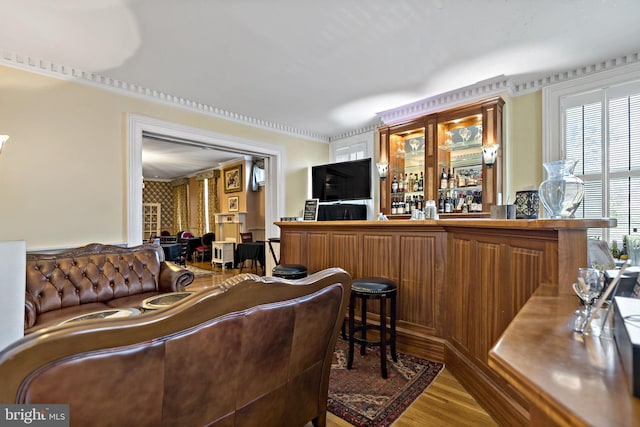 living room with bar area and hardwood / wood-style floors