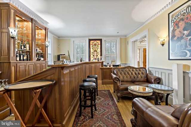 bar with crown molding and hardwood / wood-style floors