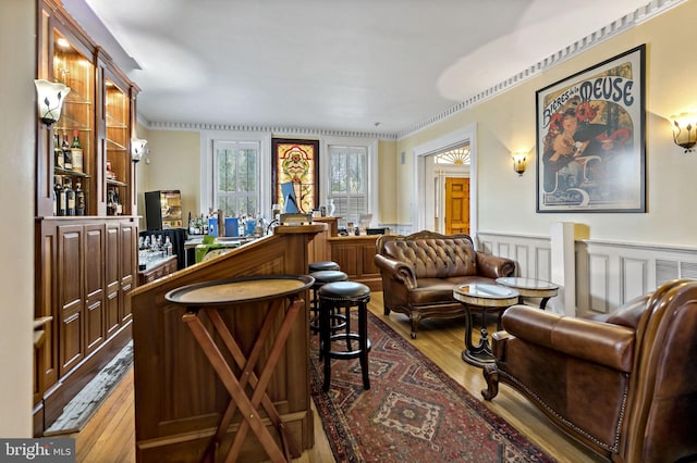 bar featuring wood-type flooring and ornamental molding