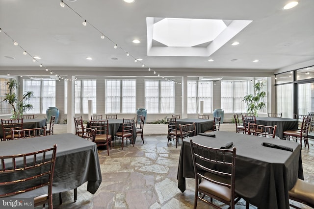 dining area with ornamental molding and a skylight