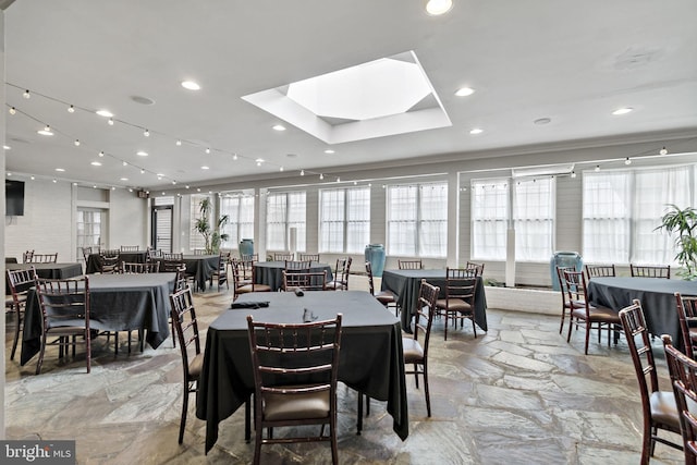 dining space with a skylight and crown molding