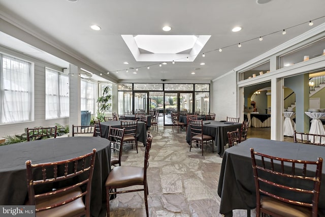 dining area with crown molding and a skylight