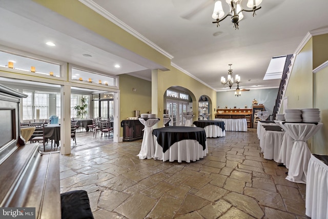 dining room with ornamental molding and ceiling fan with notable chandelier