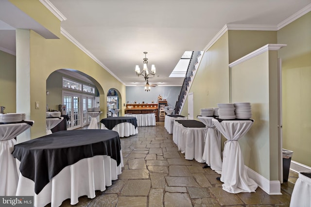 interior space featuring crown molding, french doors, and a notable chandelier