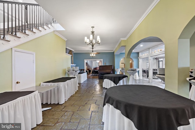 dining room with a healthy amount of sunlight, ornamental molding, and a chandelier