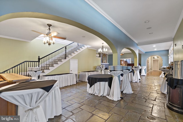 interior space with ceiling fan with notable chandelier and ornamental molding