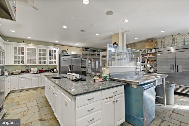 kitchen featuring a large island with sink, stainless steel built in fridge, and white cabinets