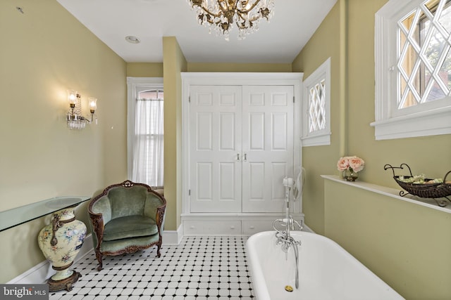 bathroom with a bathtub, tile patterned flooring, a chandelier, and a wealth of natural light