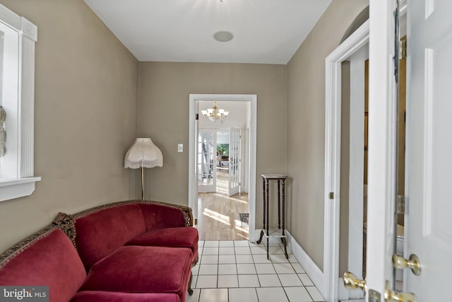 sitting room featuring a notable chandelier and light tile patterned floors