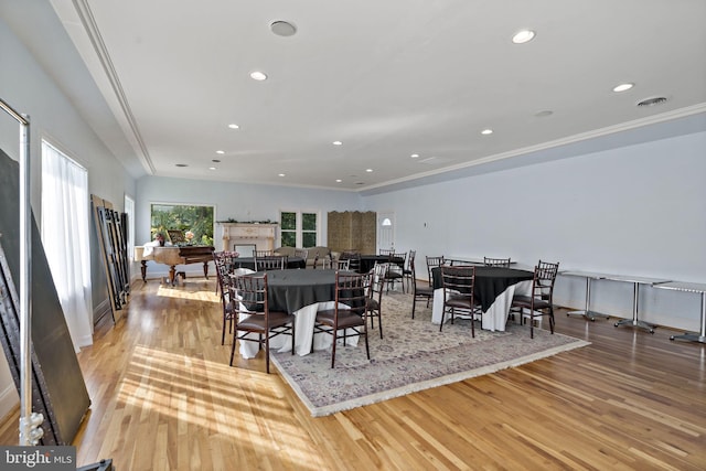 dining area with crown molding and light hardwood / wood-style floors