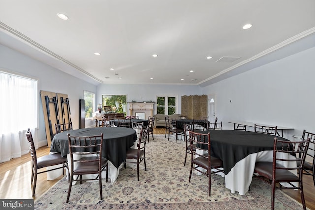 dining space featuring light wood-type flooring and crown molding