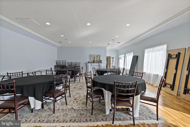 dining space with light hardwood / wood-style floors and ornamental molding