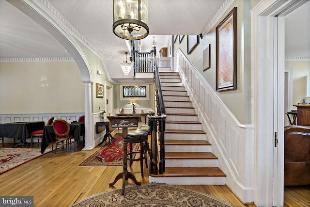 stairway featuring wood-type flooring and an inviting chandelier