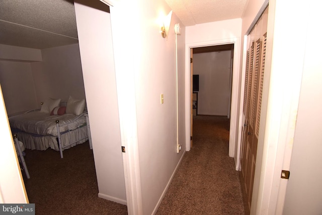 hall with a textured ceiling and carpet flooring