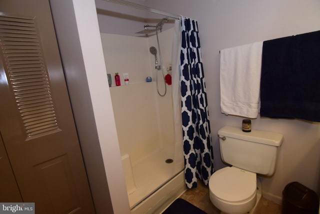 bathroom with toilet and a shower with shower curtain