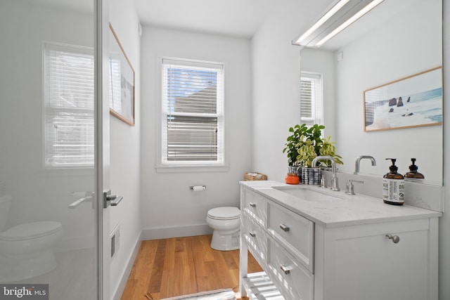 bathroom featuring vanity, hardwood / wood-style flooring, and toilet