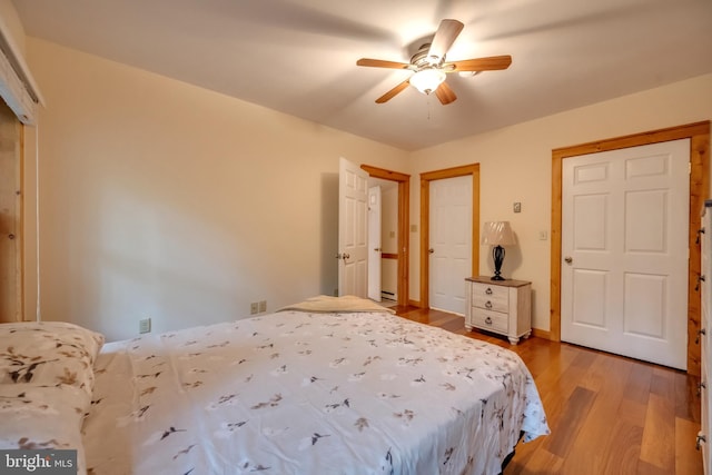 bedroom with light wood-type flooring, baseboard heating, and ceiling fan