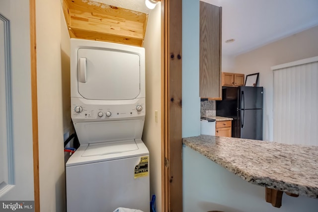 laundry room with stacked washing maching and dryer