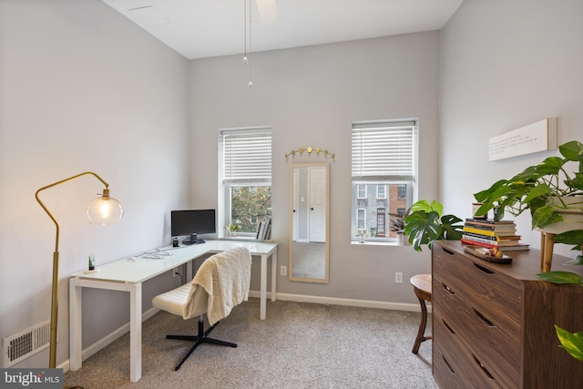 carpeted home office featuring ceiling fan and plenty of natural light