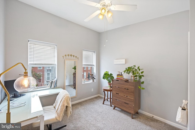 carpeted home office featuring ceiling fan