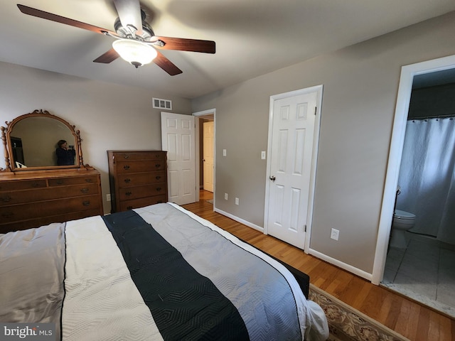 bedroom with hardwood / wood-style floors, ceiling fan, and ensuite bathroom