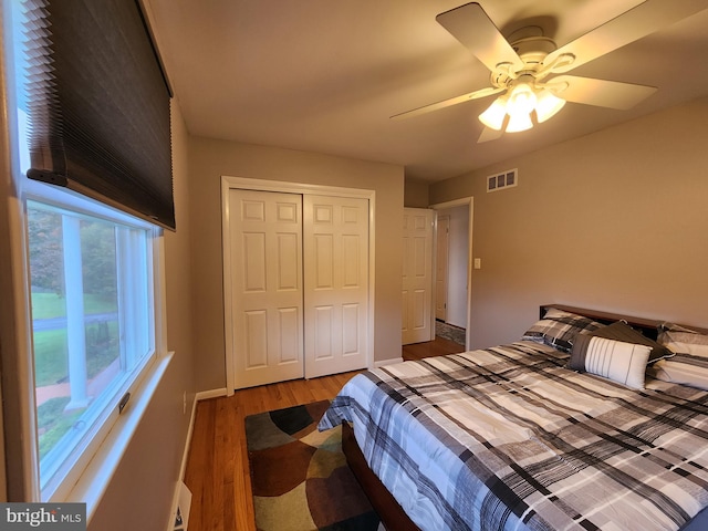 bedroom with ceiling fan, a closet, and light hardwood / wood-style flooring