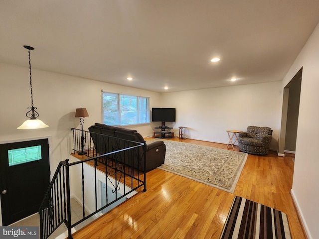 living area with light wood-type flooring, baseboards, and recessed lighting