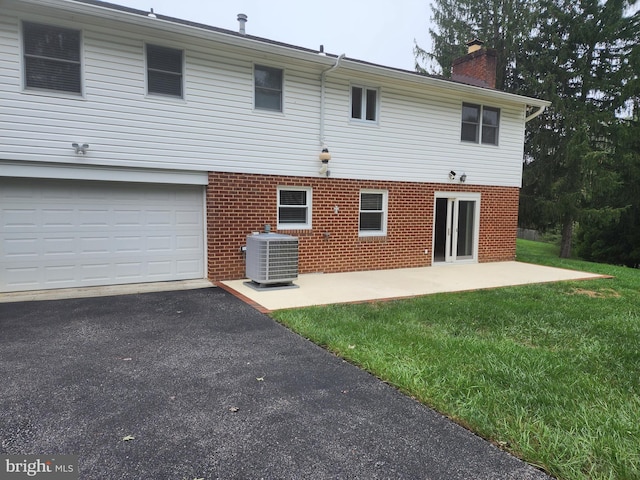 rear view of house with a yard, central AC unit, and a patio