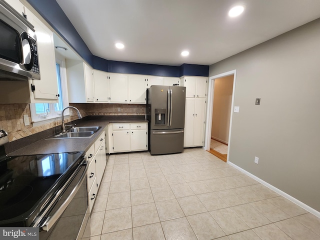 kitchen with light tile patterned flooring, sink, white cabinets, stainless steel appliances, and backsplash