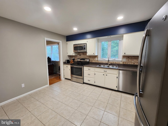 kitchen featuring white cabinetry, stainless steel appliances, sink, and light tile patterned floors