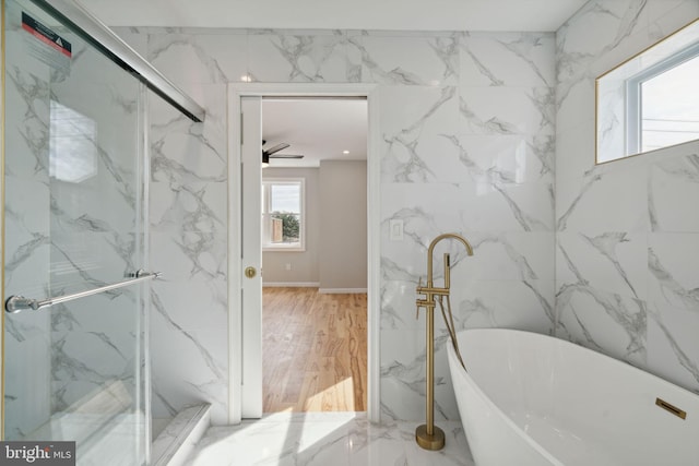 bathroom with hardwood / wood-style floors, ceiling fan, and shower with separate bathtub