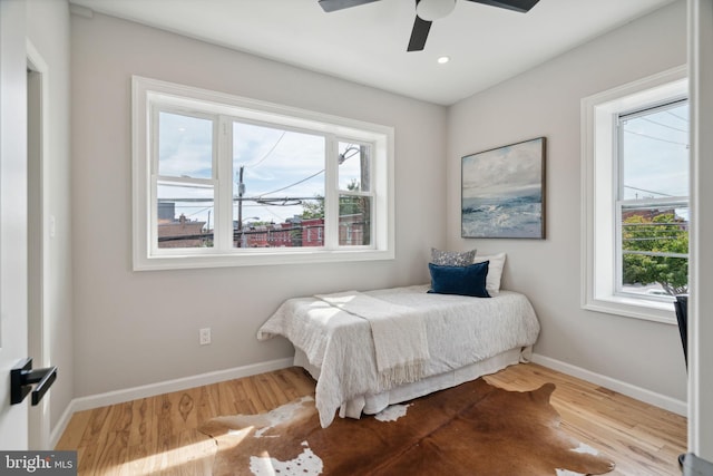 bedroom featuring multiple windows, ceiling fan, and light hardwood / wood-style flooring