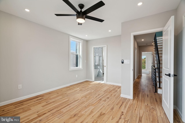 empty room with ceiling fan and light hardwood / wood-style flooring