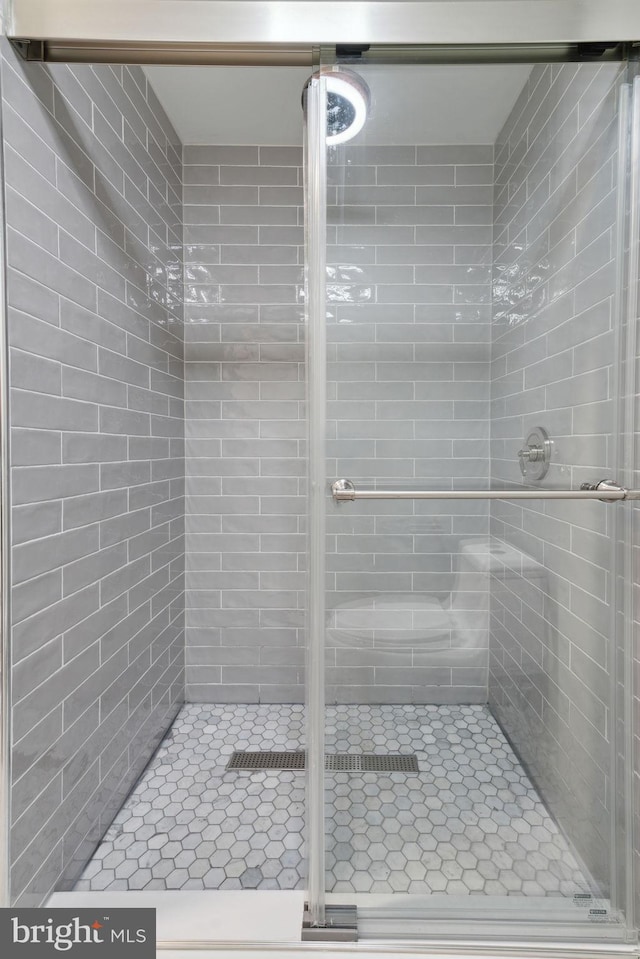 bathroom with a shower with door