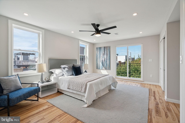 bedroom featuring multiple windows, ceiling fan, and light wood-type flooring