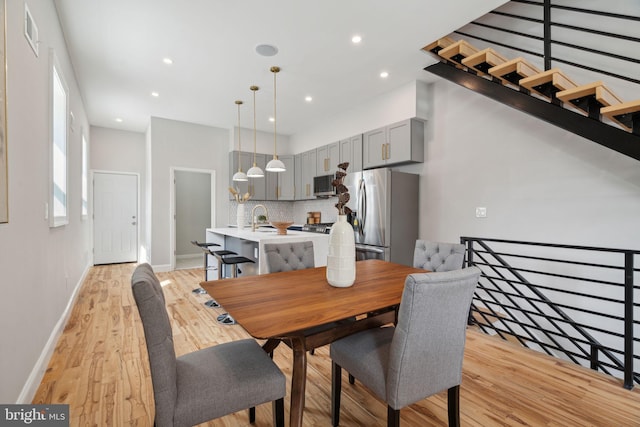 dining space featuring light wood-type flooring and sink