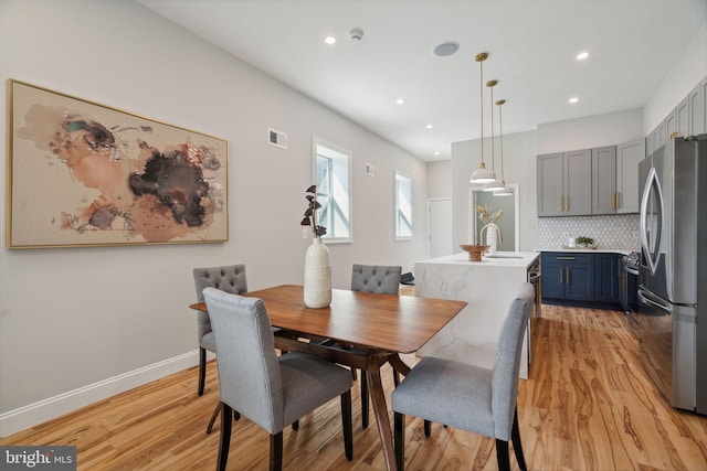 dining area with light wood-type flooring and sink