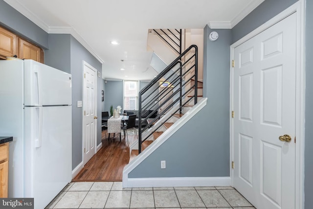 foyer featuring light tile patterned flooring and ornamental molding