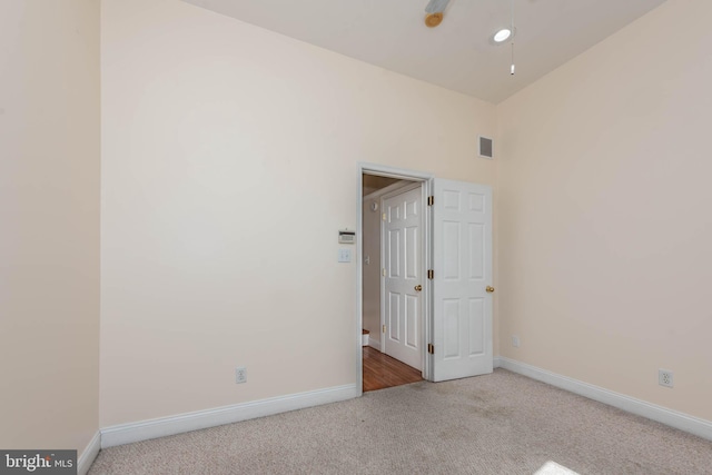 carpeted empty room featuring lofted ceiling and ceiling fan