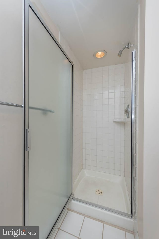 bathroom featuring tile patterned floors and a shower with shower door