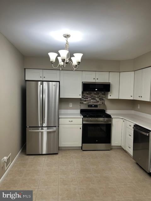 kitchen featuring appliances with stainless steel finishes, white cabinets, extractor fan, and decorative light fixtures