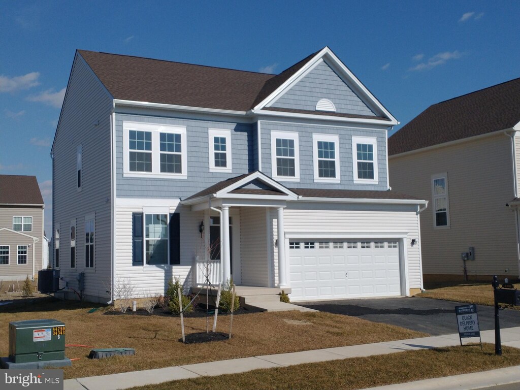 view of front of home with a front lawn and a garage