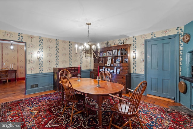 dining area featuring wood-type flooring and an inviting chandelier