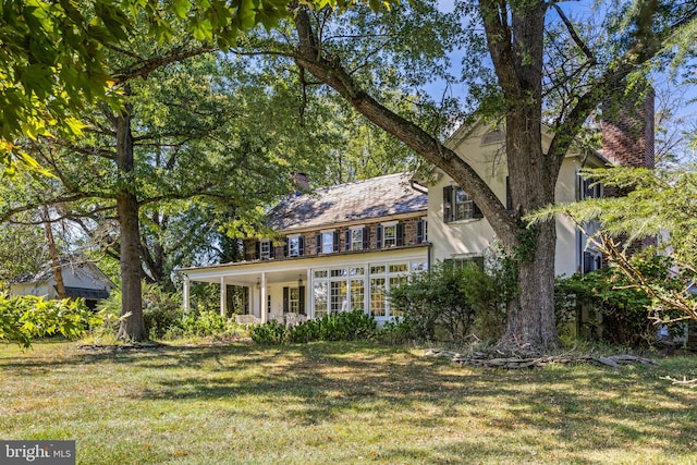 rear view of property with a lawn